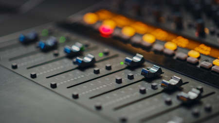 Modern Music Record Studio Control Desk with Automatic Equalizer, Mixer and other Professional Equipment. Switchers, Buttons, Faders, Sliders, Motorized Faders Move, Record, Play Hit Song. Close-upの写真素材