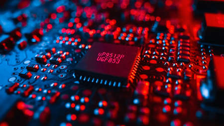 Close-up Macro Shot of Microchip, CPU Processor, Printed Circuit Board or Computer Motherboard with Components: Inside of Electronic Device. Neon Colors. Cyber Security Safety Concept.の写真素材