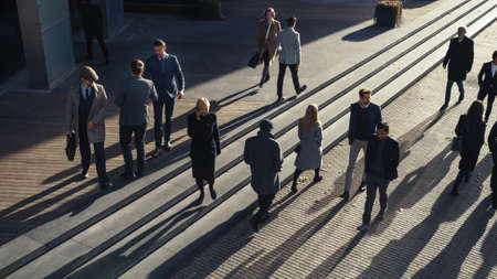 Office Managers and Business People Commute to Work in the Morning or from Office on a Sunny Day on Foot. Pedestrians are Dressed Smartly. Two Businessmen Shake Hands. Shot from Above.の写真素材