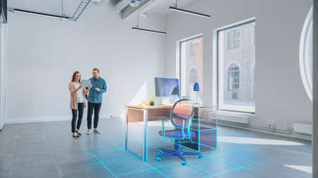 In Empty New Office: Female Interior Designer and Male Office Architect Talk, Use Augmented Reality Software on Digital Tablet Computer to Choose and Place 3D Furniture. VFX Special Effectsの写真素材