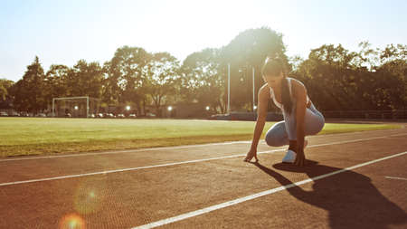 Beautiful Fitness Woman in Light Blue Athletic Top and Leggings is Starting a Sprint Run in an...
