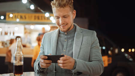 Handsome Young Man Playing a Very Addictive Online Video Game in a Casual Suit. Hes Using a...