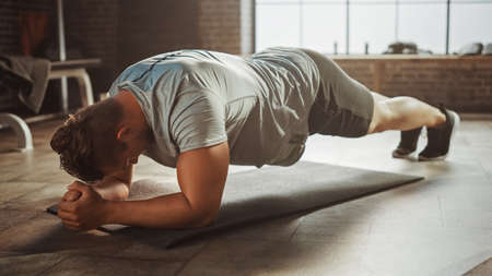 Strong Masculine Male is Holding a Plank Position in Order to Exercise His Core Strength. Man is...