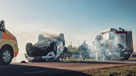 On the Car Crash Traffic Accident Scene: Paramedics and Firefighters Rescue Injured Victims Trapped...