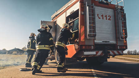 Rescue Team of Firefighters Arrive on the Car Crash Traffic Accident Scene on their Fire Engine....