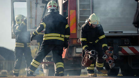 Rescue Team of Firefighters Arrive on the Car Crash Traffic Accident Scene on their Fire Engine....