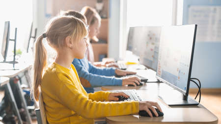 Elementary School Computer Science Classroom: Cute Little Girl Uses Personal Computer, Learning...