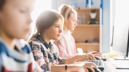 Elementary School Classroom: Smart Girl is Uses Personal Computer, Learning How to Use Internet...