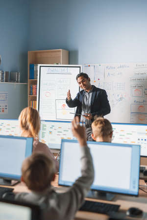 School Class: Portrait of the Enthusiastic and Motivated Teacher Using Digital Tablet Computer, Asks...