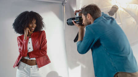 Attractive Black Girl with Lush Curly Hair Posing for a Fashion Magazine Photoshoot. Beautiful Girl Smiles during Professional Studio Photo Shoot for Fashion Magazine. Portrait Shotの写真素材