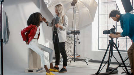 Backstage of the Photo Shoot: Make-up Artist Applies lipstick Makeup on Beautiful Black Model with...