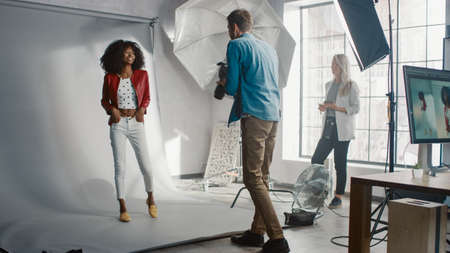 Beautiful Black Model Posing for a Photographer, he Takes Pictures with Professional Camera. Stylish...