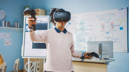 Elementary School Computer Science Class: Cute Girl Wearing Augmented Reality Headset and Using...