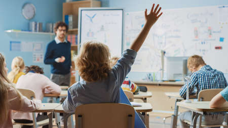 Brilliant Schoolboy Listens Attentively to His Teacher Explaning the Lesson. In Elementary School...