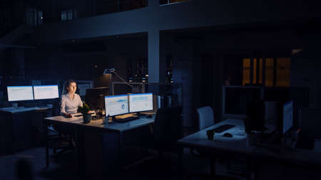 Working Late at Night in the Office: Businesswoman Uses Desktop Computer, Analyzing, Using...