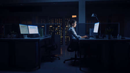 Working Late at Night in the Office: Businesswoman Uses Desktop Computer, Analyzing, Using...