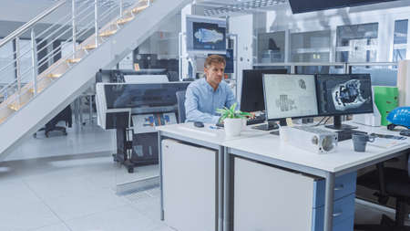 Senior Male Engineer Working on Design for Industrial Engine Prototype. Specialists Work with...