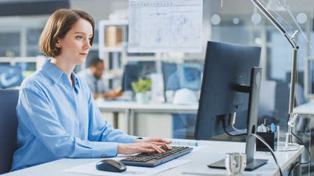 In the Industrial Engineering Facility: Portrait of the Smart and Beautiful Female Engineer Working...