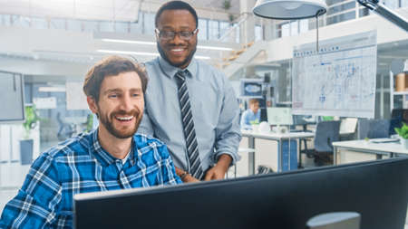 In the Industrial Engineering Facility: Portrait of the Handsome Male Engineer Working on Desktop...