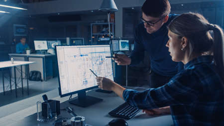 Engineer Working on Desktop Computer, Screen Showing CAD Software with Technical Blueprints, Her...