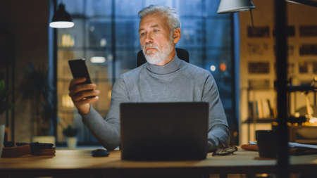 Portrait of the Handsome and Successful Middle Aged Bearded Businessman Working at His Desk Using...