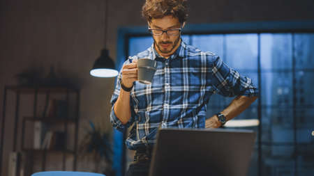 Young Creative Designer Working at His Desk, Concentrated on the Paperwork, Choosing Right Design,...