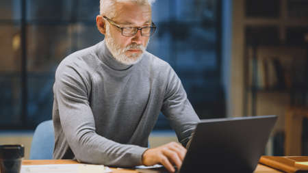 Portrait of the Handsome and Successful Middle Aged Bearded Businessman Working at His Desk Using...