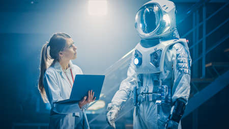 Shot of an Aerospace Scientist Wearing White Coat Use Computer for Designing New Space Suit Adapted...