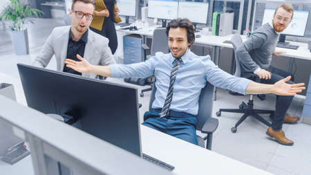 Handsome Businessman Uses Desktop Computer, Cheerfully Celebrates Successful Business Transaction...