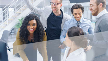 In Modern Office: Diverse Team of Young Motivated Businessmen and Businesswoman Work on Computer,...