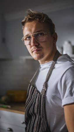 Portrait Shot of a Handsome Cook in White Shirt and Apron Posing on Camera in a Bright Modern...
