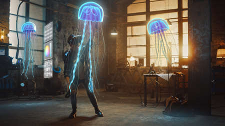 Female Artist Wearing Augmented Reality Headset Working on Abstract 3D Jellyfish Sculpture with Joysticks, Uses Gestures To Create High-Tech Internet Multimedia Concept Art.3D Animation Special Effectの写真素材