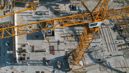 Aerial View of a New Constructions Development Site with High Tower Cranes Building Real Estate. Heavy Machinery and Construction Workers are Employed.の写真素材