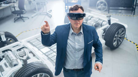 Automotive Engineer Using Augmented Reality Headset Making Touching Gestures. In Innovation...