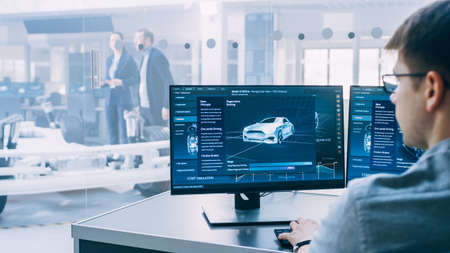 Professional Engineer Works on a Computer with a 3D CAD Software and Tests the Electric Car Chassis...