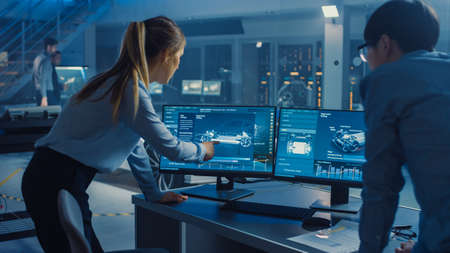 Female and Male Engineers are Discussing the 3D CAD Software Render of an Electric Concet Car. High...