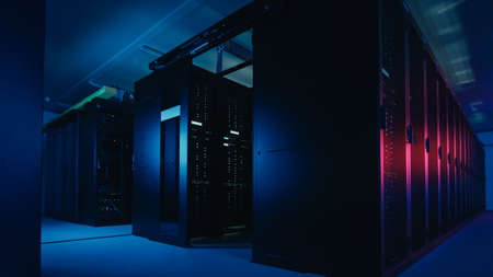 Shot of Data Center With Multiple Rows of Fully Operational Server Racks. Modern Telecommunications, Cloud Computing, Artificial Intelligence, Database, Supercomputer Technology Concept. Shot in Darkの写真素材