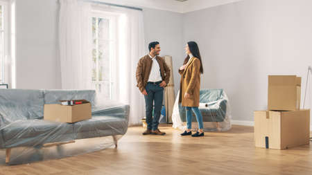 Happy and Excited Young Couple Look Around In Wonder at their Newly Purchased / Rented Apartment....