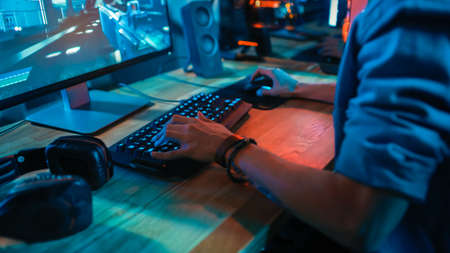Close-Up Hands Shot Showing a Gamer Using the Keyboard while Playing an Online Shooter Video Game....