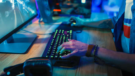 Close-Up Hands Shot Showing a Gamer Using the Keyboard while Playing an Online Shooter Video Game....