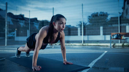 Beautiful Energetic Fitness Girl Doing Push Up Exercises. She is Doing a Workout in a Fenced Outdoor...