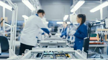 Shot of an Electronics Factory Workers Assembling Circuit Boards by Hand While it Stands on the...
