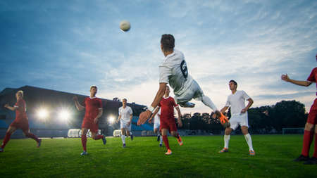 Soccer Player Receives Successful Pass and Kicks Ball to Score Amazing Goal doing Bicycle Kick. Shot Made on a Stadium Championship.の写真素材
