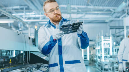 High-Tech Factory: Quality Control Inspector Checks Electronic Printed Circuit Board it for Damages....
