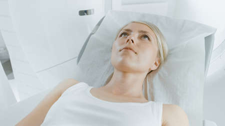 Close-up Portrait Shot of a Female Patient Lying on a CT or PET or MRI Scan Bed, Machine Scans Her...