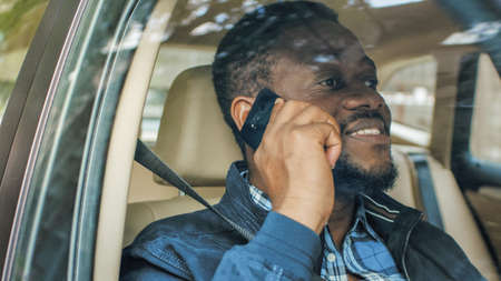 Handsome Young Entrepreneur Traveling on a Passenger Seat of a Car Makes a Phone Call, Talks with...