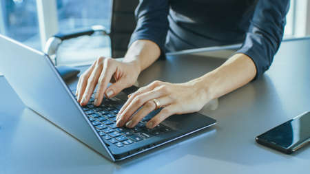 Close-up On the Hands of a Businesswoman Typing on a Laptop Keyboard. Female Using Laptop in the...
