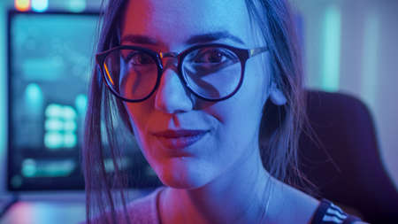 Portrait of the Beautiful Young Pro Gamer Girl Sitting at Her Personal Computer and Looks into...