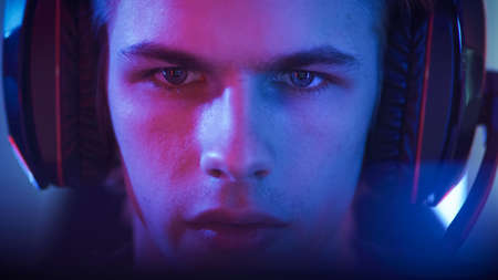Portrait of the Young Handsome Pro Gamer Playing in Online Video Game. Neon Colored Room. e-Sport...