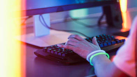 Close-up on the Hands of the Gamer Playing in the Video Game on a Keyboard and Using Mouse. Stylish...